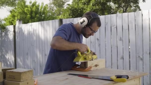 用电动工具电动刨床切割木块室外作业的木匠 — 图库视频影像