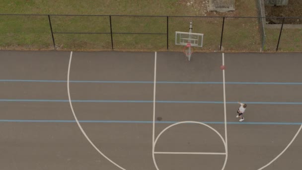 Aerial Two Teen Boys Shooting Hoops Blacktop Basketball Court — Stock Video