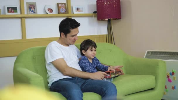 Slider Tiro Pai Filho Brincando Com Caminhão Brinquedo Sofá Sala — Vídeo de Stock