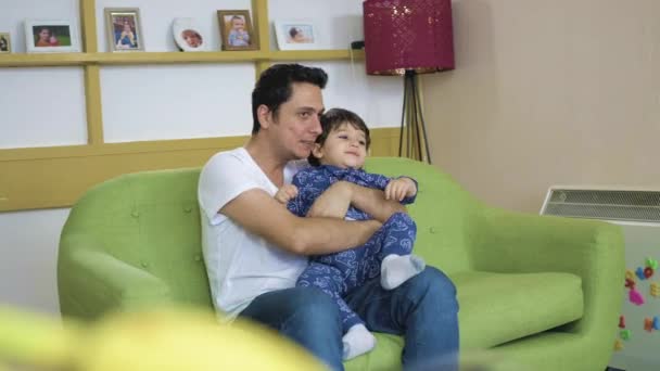 Батько Маленький Син Сидять Разом Дивляться Телевізор Зеленому Дивані Вдома — стокове відео