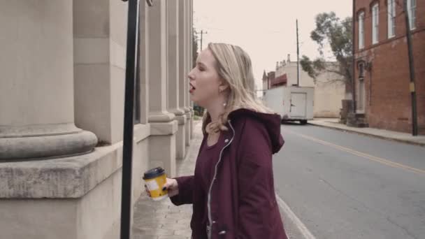 거리를 횡단하는 여성의 자신에게 노래를 부르고 뜨거운 음료를 — 비디오