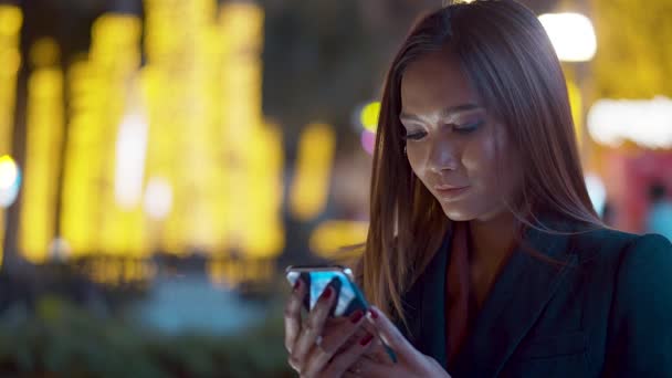 Jovem Atraente Verificando Seu Smartphone Nas Luzes Cidade Noite Fundo — Vídeo de Stock