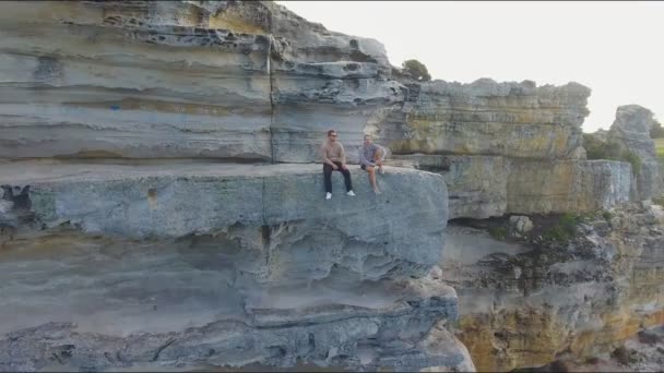 Amis Assis Sur Une Falaise Rocheuse Surplombant Les Belles Vagues — Video