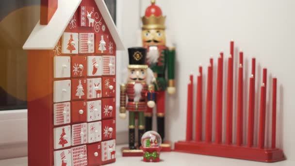 Happy Little Boy Takes Sweet From Advent Calendar House Form With Christmas Nutcrackers in Background. Traditional Christmas Calendar for Kids