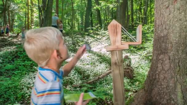 Niño Pequeño Marcando Sello Tarjeta Entrada Lado Árbol Una Exuberante — Vídeos de Stock