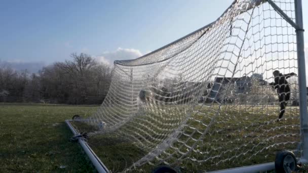 SLOW MOTION:  (48 FPS) A soccer ball slams an icy net of a soccer goal exploding shattered ice into the air