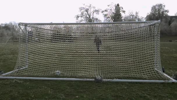 慢动作 120 Fps 一个人踢了一个足球 这个足球把一个足球进球的冰网扔向空中 把破碎的冰块炸成了碎片 — 图库视频影像