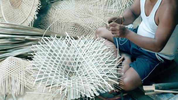 Muž dělá kruhovou obruč a nasazuje si bambusový klobouk, aby získal správný tvar. Proces výroby ručně vyrobeného bambusového klobouku