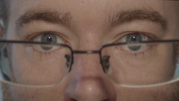 Close up of glasses being put in front of pair of blue eyes looking into camera