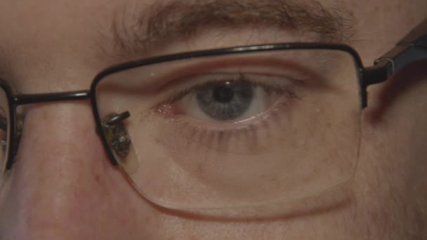 Κοντινό Μπλε Αρσενικό Μάτι Behing Γυαλιά Ανάγνωση Και Κοιτάζοντας Γύρω — Αρχείο Βίντεο
