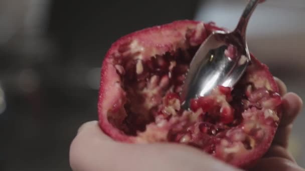Yarım Dilimlenmiş Nar Meyvesini Sıkıca Tutarken Tüm Tohumları Çıkarırken Yakın — Stok video