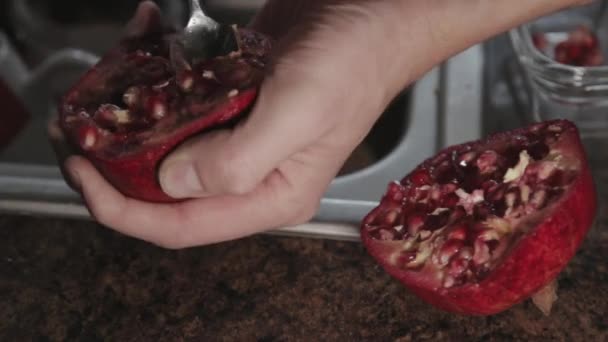 Deseeding A Sliced Pomegranate Fruit With A Spoon - Close Up Shot
