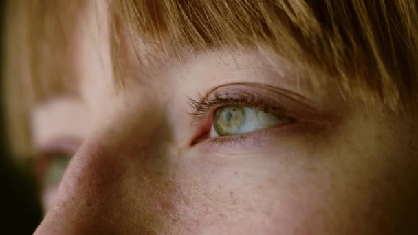 片目を開けている若い女の極端なクローズアップ 緑の目と選択的浅い焦点 — ストック動画