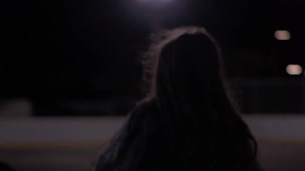 低角度タイトショットの十代の女の子ドリブルバスケットボールその後撮影に屋外コートで夜にライト — ストック動画