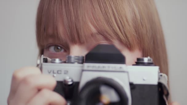 Studio záběr ženy pomocí vintage kamery ve zpomaleném filmu.