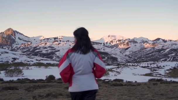 Eine Frau Läuft Winter Zeitlupe Auf Eine Reihe Schneebedeckter Berge — Stockvideo