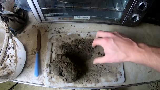 用一块粘土在厨房桌子上干活的一只手 — 图库视频影像