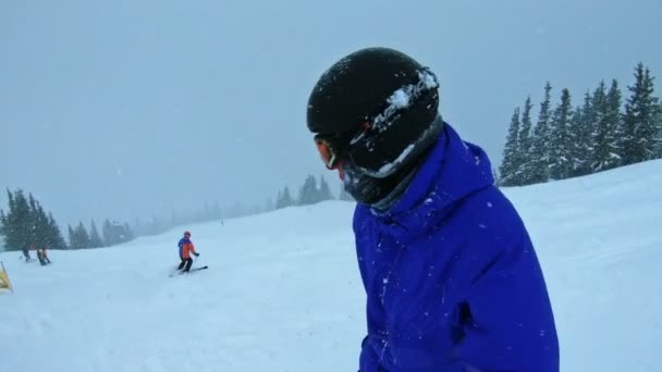 Snowboardista klouže dolů během sněhové bouře.