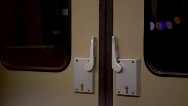 普通地铁中老式地铁门的闭锁 透过窗户可以看到夜空和城市的灯火 — 图库视频影像