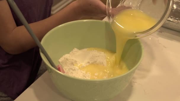 Ein Mädchen Gießt Geschmolzene Butter Eine Große Schüssel Mit Mehl — Stockvideo