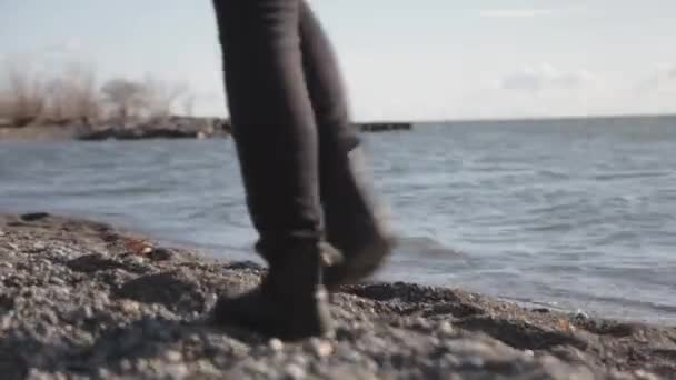 在阳光明媚的日子里 一个女人脚踏着湖面散步 浪花汹涌 拍打着湖面的背景 — 图库视频影像