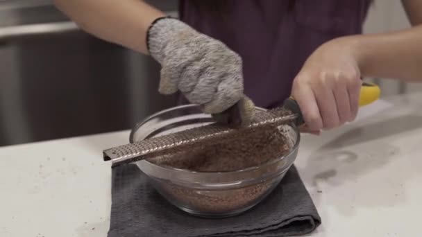 Young Girl Grates Chocolate Bowl Melting While Making Millionaire Shortbread — Stock Video