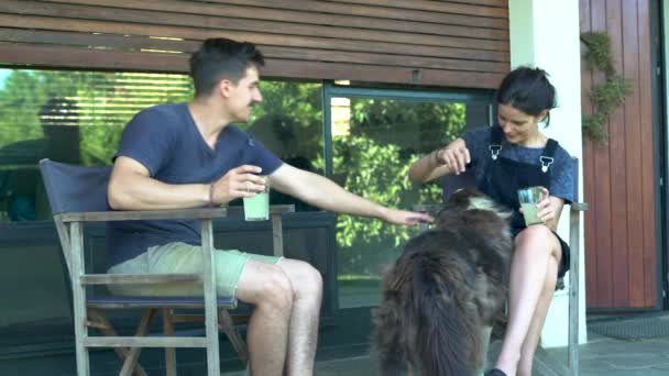 Young Couple Talking Drinking Dog Front Yard — Stock Video