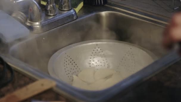 カナダ 台所のシンクでストレーナーを使用して熱い蒸し餃子を訓練 クローズアップショット — ストック動画