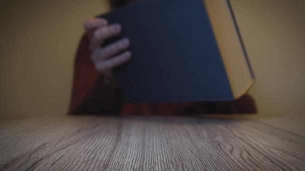 Vrouw Opent Boek Een Houten Tafel Begint Lezen Slow Motion — Stockvideo