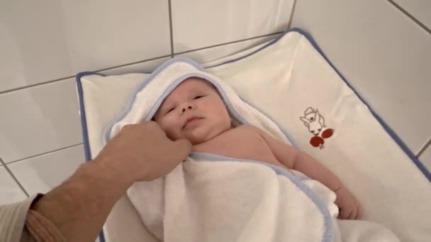 Gelukkige Pasgeboren Baby Jongen Gewikkeld Een Handdoek Vaders Handen Strelen — Stockvideo