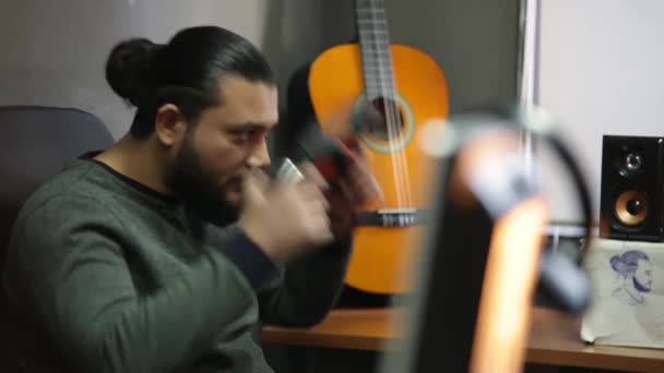 Mladý muž nosí bezdrátové sluchátka chlazení poslech hudby sedět na studiu, šťastný uvolněný chlap těší salonek zvuk s kytarovým pozadím v klidné náladě pocit