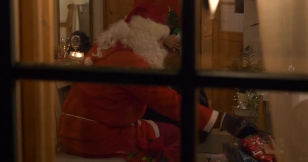 Auténtico Santa Repartiendo Regalos Los Niños Escena Navidad Través Ventana — Vídeo de stock