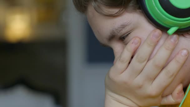 Teen Boy Trägt Kopfhörer Und Blickt Konzentriert Nach Unten Nahaufnahme — Stockvideo