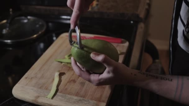 Una Mujer Cocina Pelando Cuidadosamente Mango Inmaduro Usando Pelador Metal — Vídeos de Stock