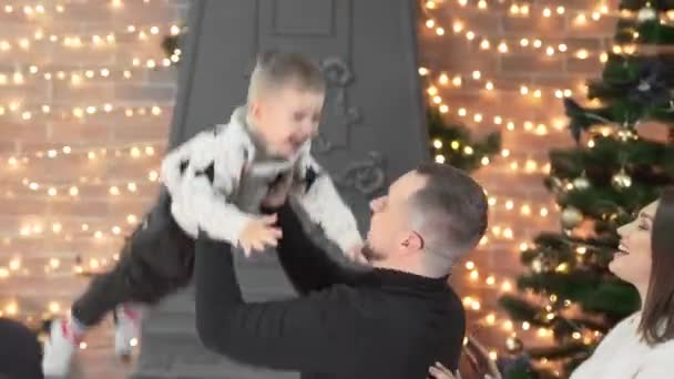 可爱的家人在新年前在家里准备了一棵圣诞树 父亲正辗转反侧 抓住他的小儿子 他笑是因为他喜欢它 — 图库视频影像