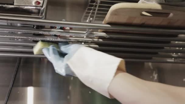 濡れた石鹸スポンジでキッチンステンレス製のオーバーシンクラックドライヤーを掃除する 閉じるショット — ストック動画