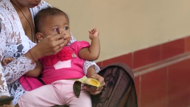 Νεαρή Κόρη Που Τρέφεται Φρέσκια Μπανάνα Από Μαμά Που Ξύνει — Αρχείο Βίντεο