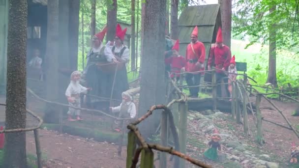 Wykonawcy Średniowiecznym Jarmarku Przechodzą Obok Małych Kabin Lesie Niosąc Kosze — Wideo stockowe
