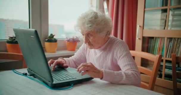 Grandmotehr ül a laptopja előtt és böngészi az internetet