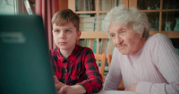 Gyermek megmutatja nagymama, hogyan kell használni egy laptop és böngészi az interneten belül