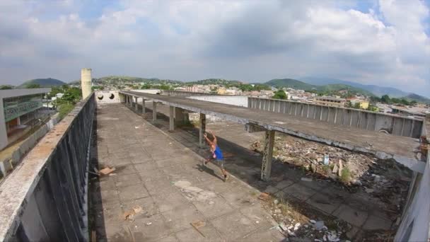 Slow Motion Video Młodego Freerunnera Robiącego Gwiazdę Dachu Opuszczonego Budynku — Wideo stockowe