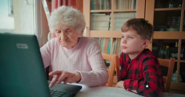 Großmutter Tippt Auf Laptop Tastatur Und Enkel Schaut Ihr — Stockvideo