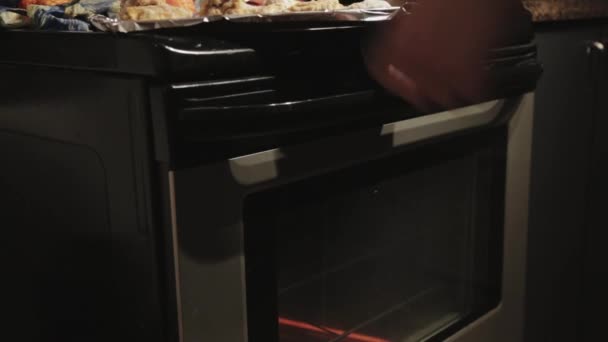 焼き立てのオーブンの中にパン肉を入れる男 Close Shot — ストック動画