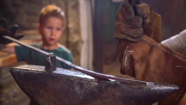 Primer Plano Niño Viendo Hermano Martillando Pedazo Hierro Rojo Caliente — Vídeo de stock