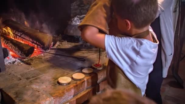 在火堆的帮助下 小男孩在圆木块上使用热烙铁 慢动作 — 图库视频影像