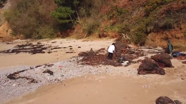 海草跟踪左岸妇女捡起垃圾的空中景观 — 图库视频影像