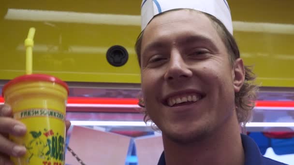 食品コンセッションで若い白人男性 カーニバルで新鮮な圧搾レモネードを販売 遊園地 — ストック動画