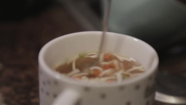 一个人在有蔬菜的杯子里用勺子搅拌美味的汤 — 图库视频影像