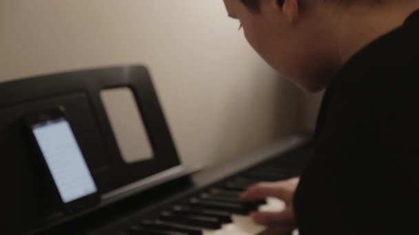 Sağ Elini Telefonla Piyano Çalmak Için Kullanan Bir Gencin Yan — Stok video