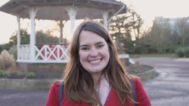 Vrouw Glimlachend Naar Camera Een Park Met Een Veelhoekige Bandstandaard — Stockvideo